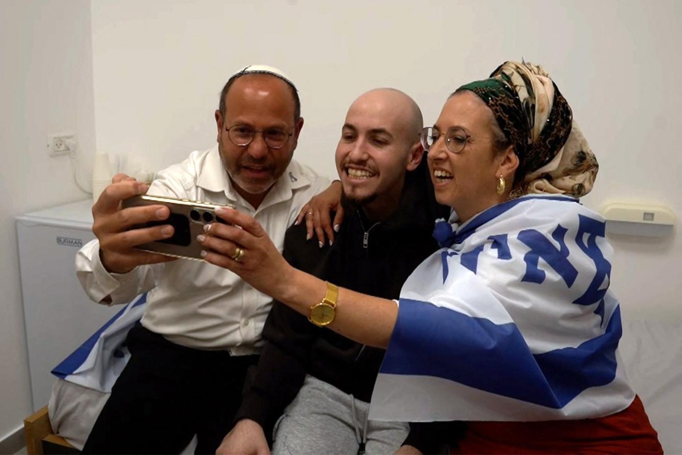 Esta fotografía, difundida por el ejército israelí, muestra al rehén israelí liberado Eitan Mor (centro), uno de los ex cautivos en Gaza desde los ataques del 7 de octubre de 2023 perpetrados por militantes palestinos, posando para una