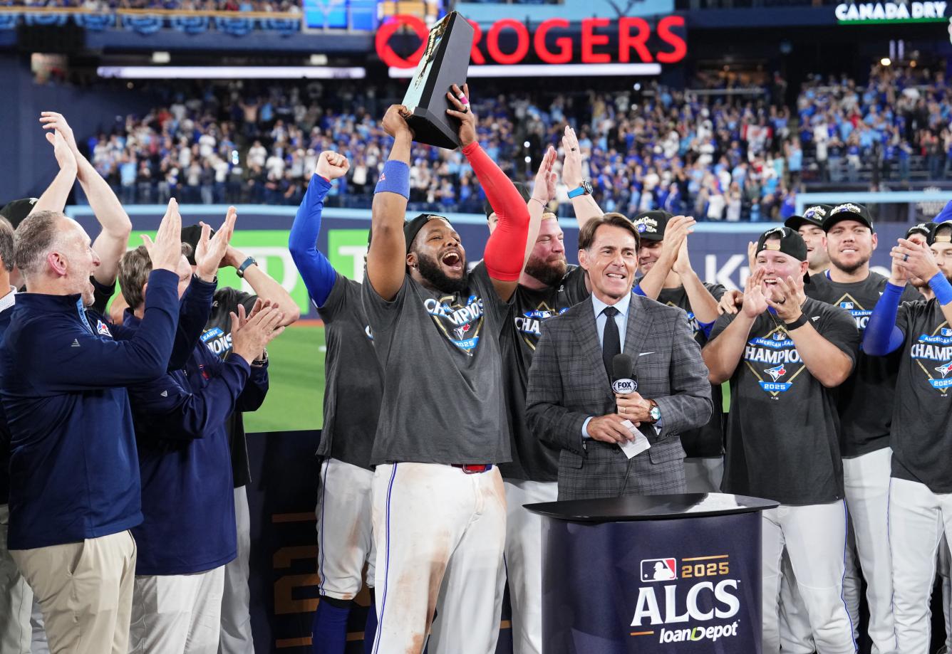 Vladimir Guerrero Jr. #27 of the Toronto Blue Jays lifts the William Harridge Trophy after winning game seven of the American League Championship Series against the Seattle Mariners at the Rogers Centre on October 20, 2025 in Toronto, Ontario.