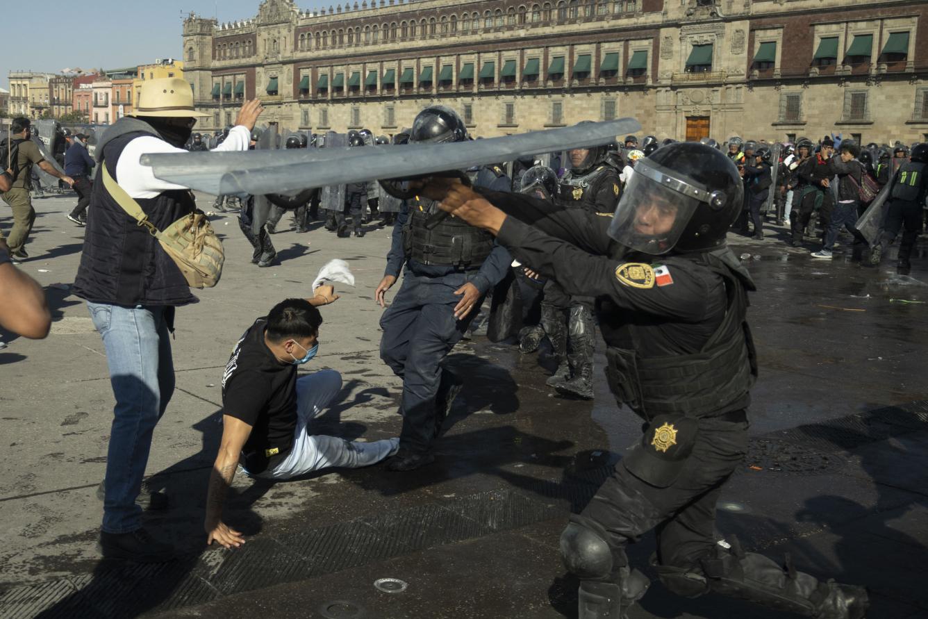 Demonstrators clash with riot police at a rally against the government of Mexico's President Claudia Sheinbaum at Zocalo Square in Mexico City on November 15, 2025. Thousands of people marched through the streets of Mexico City on Saturday to protest against drug violence and the security policies of President Claudia Sheinbaum's government. (Photo by Eva FONSECA / AFP)