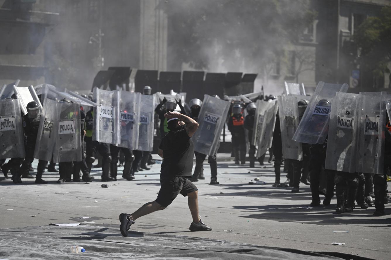 A demonstrator waves a Mexican flag during a rally against the government of Mexico's President Claudia Sheinbaum at Zocalo Square in Mexico City on November 15, 2025. Thousands of people marched through the streets of Mexico City on Saturday to protest against drug violence and the security policies of President Claudia Sheinbaum's government. (Photo by Eva FONSECA / AFP)