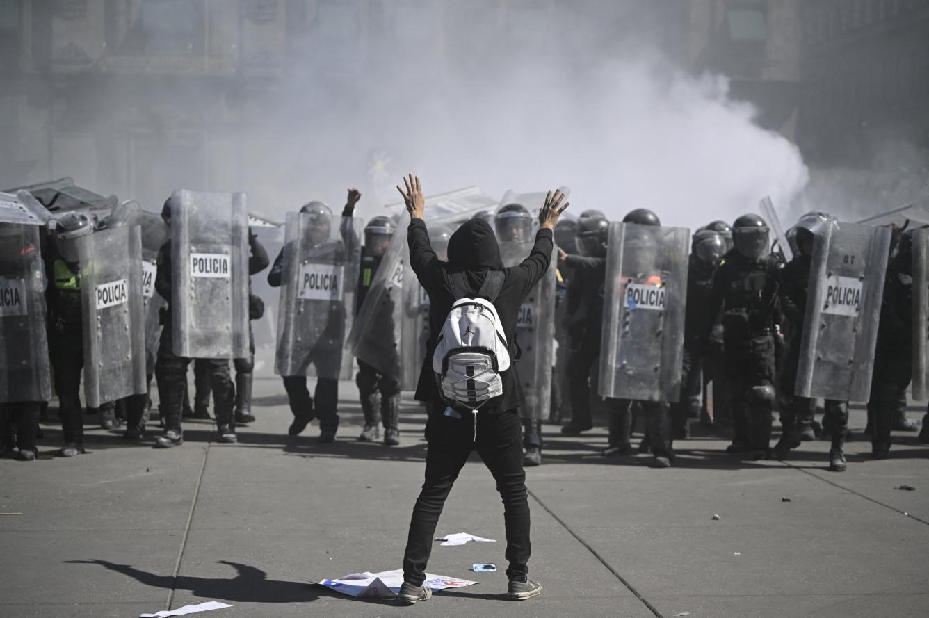 A man throws a rock at riot police during a demonstration against the government of Mexico's President Claudia Sheinbaum in Mexico City on November 15, 2025. (Photo by Alfredo ESTRELLA / AFP)