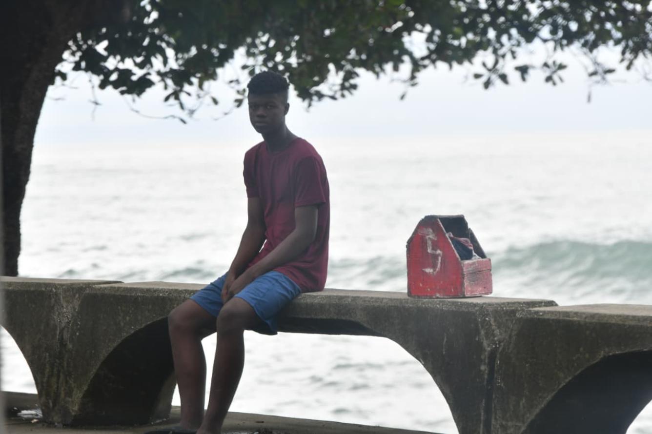 Jefri Jhosep junto a su caja de limpia botas, en espera del pan del día. Una mirada que refleja muchas preguntas.
