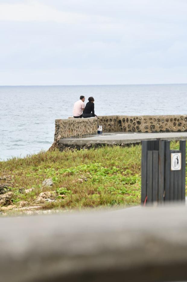 Una pareja de enamorados sentados mirando el mar mientras sostenían una conversación