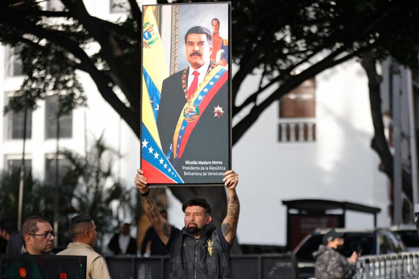 Un partidario del presidente venezolano, Nicolás Maduro, sostiene un retrato suyo en Caracas el 3 de enero de 2026, después de que las fuerzas estadounidenses capturaran al líder venezolano, Nicolás Maduro, tras lanzar un 
