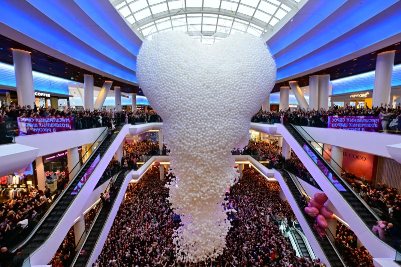 Globos blancos caen en cascada sobre una gran multitud en un centro comercial después de que se abriera una red gigante para globos en forma de corazón como parte de las celebraciones del Día de San Valentín en Moscú, Rusia, el 14 de febrero de 2026.