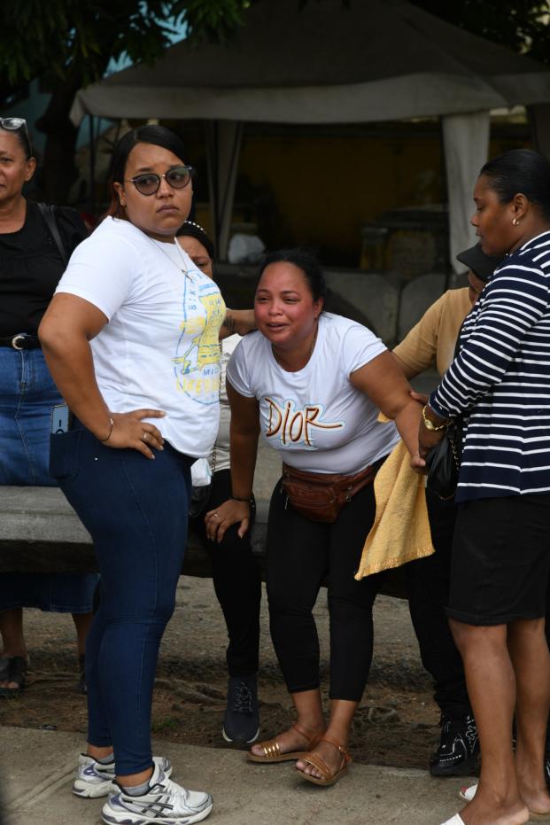 Familiares de Darlin Mercado lloran su perdida junto a su madre frente al Inacif del cementerio.