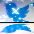 Esta foto ilustrativa creada en Washington, DC, el 24 de julio de 2023, muestra el nuevo logotipo X de Twitter reflejado en el logotipo del pájaro de Twitter