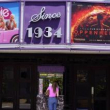 Una persona compra boletos de cine debajo de una marquesina con las películas “Barbie” y “Oppenheimer” en el cine.