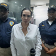 Karla María Moya Boada, la supuesta cirujana plástica de origen venezolano posa junto a dos agentes de la Dirección General de Migración (DGM).
