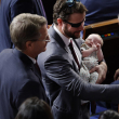 El representante estadounidense Dan Crenshaw (R-CO) (C) sostiene a un bebé junto con el representante Tim Burchett (R-TN) (L) y el representante Trent Kelly (R-MS) como la Cámara de Los representantes celebran su segunda ronda de votación para un nuevo presidente de la Cámara en el Capitolio de los Estados Unidos el 18 de octubre de 2023 en Washington, DC.