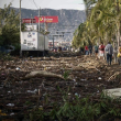La gente camina junto a los escombros que quedaron después del paso del huracán Otis en Acapulco