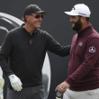 El golfista español Jon Rahm saluda al estadounidense Phil Mickelson en el primer tee durante una ronda de práctica para el Abierto Británico de golf.