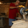 Fotografía muestra a Georges Thevenet en su taller 3R-Elements cortando madera.