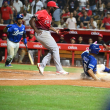 Gustavo Núñez anota la carrera de la victoria de los Tigres del Licey en entradas extras frente al pitcher Henry Sosa de los Leones del Escogido