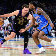 El ala-pívot de Los Angeles Lakers, Luka Dončić (77), penetra contra el base de los Oklahoma City Thunder, Cason Wallace (22), durante la primera mitad de un partido de baloncesto de la NBA.