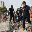 Momento en que movilizan el cadáver de un niño recuperado bajo los escombros.