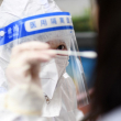 Un trabajador médico obtiene una muestra de hisopo de un residente para detectar el coronavirus Covid-19 en Wuhan, en la provincia central china de Hubei, el 22 de febrero de 2022.
STR / AFP