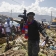 Jimmy Cherizier, también conocido como Barbacoa, líder de la banda "G9 y Familia", se sitúa junto a un montón de basura para llamar la atención sobre las condiciones en las que vive la gente mientras lidera una marcha contra los secuestros por el barrio de La Saline en Puerto Príncipe, Haití, el 22 de octubre de 21. Foto: Odelyn Joseph/AP.