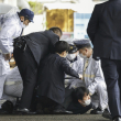 Un hombre que se cree que es sospechoso, en el centro, es atrapado por la policía después de que supuestamente arrojó "el objeto sospechoso", cuando el primer ministro japonés, Fumio Kishida, visitó el puerto de Saikazaki para un evento de campaña electoral en Wakayama, oeste de Japón, el sábado 15 de abril. , 2023. Kishida fue evacuado ileso el sábado después de que alguien arrojara un artefacto explosivo en su dirección mientras hacía campaña en el puerto pesquero en el oeste de Japón, dijeron las autoridades. (Kyodo News vía AP)