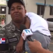 Agente de la Policía Nacional mientras sostiene a su hijo en brazos.