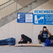 Grupo de migrantes, la mayoría provenientes de Venezuela, intentando descansar en un estacionamiento en Brownsville, Texas