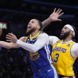 El jugador de los Warriors de Golden State Stephen Curry, a la izquierda, tira a canasta junto al jugador de los Lakers de Los Ángeles Anthony Davis.