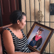 Berlinda sostiene el retrato de Joshua cuando se graduó de bachiller