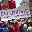 Un simpatizante gubernamental sostiene un letrero durante una marcha contra la corrupción, el sábado 25 de marzo de 2023, en Caracas, Venezuela.