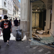 Peatones pasan por delante de una tienda de Armand Thiery dañada y saqueada en el centro de Marsella, sur de Francia, el 1 de julio de 2023, tras la cuarta noche consecutiva de disturbios en Francia por la muerte de un adolescente a manos de la policía