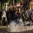 Los manifestantes huyen de una explosión de fuegos artificiales en una calle de Niza, sureste de Francia, a principios del 2 de julio de 2023, durante la quinta noche de disturbios tras el tiroteo de un conductor. adolescente en el suburbio parisino de Nanterre el 27 de junio
