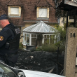 Un oficial de policía municipal se para frente a la casa dañada del alcalde de l'Hay-les-Roses, Vincent Jeanbrun, en l'Hay-les-Roses, un suburbio de París, el 2 de julio de 2023, después de que los alborotadores embistieran un vehículo