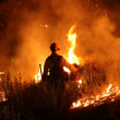 Un bombero supervisa y establece una quema controlada mientras el Incendio Rabbit arrasaba más de 7500 acres en Moreno Valley, condado de Riverside, California, el 15 de julio de 2023.