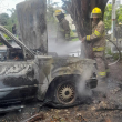 Bomberos controlando un vehículo incendiado