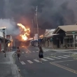 Varias personas observan mientras el humo y las llamas de los incendios forestales llegan a Front Street, en el centro de Lahaina, en Maui, Hawai, (Alan Dickar vía AP)