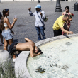 Los turistas se refrescan en una fuente en la Piazza del Popolo de Roma