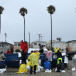 Voluntarios y miembros del Departamento de Bomberos de Long Beach llenan sacos de arena en Belmont Shore Beach el 20 de agosto de 2023 en Long Beach, California.