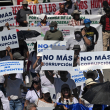 La gente porta carteles que dicen "No más corrupción" durante una protesta contra las políticas del presidente Nayib Bukele y su reelección el Día de la Independencia en San Salvador