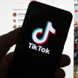 El logotipo de TikTok se ve en un teléfono móvil frente a una pantalla de computadora que muestra la pantalla de inicio de TikTok, el sábado 18 de marzo de 2023, en Boston.