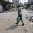 Un palestino lleva un bote de agua