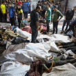 La gente se reúne alrededor de los cuerpos de los palestinos muertos en un ataque contra el hospital árabe Ahli en el centro de Gaza.