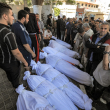 Varias personas se reúnen junto a los cuerpos envueltos de las víctimas que murieron en un ataque nocturno en el hospital Ahli Arab, en el centro de Gaza, el 18 de octubre de 2023.