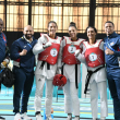 Equipo femenino de taekwondo posa junto a los técnicos de esa delegación.
