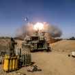 Soldados del ejército israelí se tapan los oídos mientras un obús de artillería autopropulsado dispara desde una posición cerca de la frontera con la Franja de Gaza en el sur de Israel el 6 de noviembre de 2023 en medio de las batallas en curso entre Israel y el grupo palestino Hamás en la Franja de Gaza.