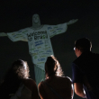 Aficionados miran la estatua del Cristo Redentor iluminada con un mensaje de bienvenida a la cantante estadounidense Taylor Swift, en Río de Janeiro, Brasil