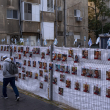 Un hombre pasa junto a una cerca con fotografías de los rehenes, en su mayoría civiles, que fueron capturados por insurgentes de Hamás durante su incursión en el sur de Israel el pasado 7 de octubre, en Ramat Gan, Israel.