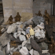 Instalación de una escena de la Natividad de Cristo con una figura que simboliza al niño Jesús tendido entre los escombros, en referencia a Gaza, en el interior de la Iglesia Evangélica Luterana de la Natividad de Belén.