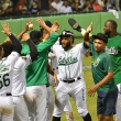 Robinson Canó celebra con sus compañeros de equipo al anotar la 6ta. carrera de los verdes, que los puso delante ante el Licey en el 7mo. episodio.