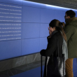 Una mujer reacciona ante los nombres de las víctimas de los atentados del 11-M, que acabaron con la vida de 192 personas el 11 de marzo de 2004, en un espacio conmemorativo de reflexión inaugurado la víspera en la estación de Atocha de Madrid el 11 de marzo de 2024.
