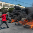 Un manifestante quema neumáticos durante una manifestación tras la dimisión de su Primer Ministro Ariel Henry, en Puerto Príncipe, Haití, el 12 de marzo de 2024.