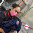Asistente de vuelo de Aeroméxico con bebé recién nacido en brazos.
